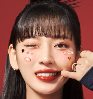 Black Rouge Glow Bokki Lip Tint in Pepper Red showing a sleek tube with vibrant red lip tint inside.