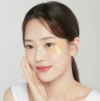 Foodaholic Hydrogel Eyepatch in gold for dark circles and under-eye spots, showing the luxurious, shiny eye patch on the skin.