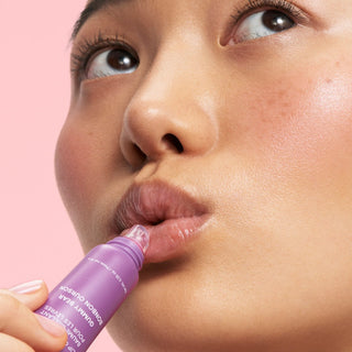 Laneige Lip Glowy Balm in various shades displayed in a sleek tube, highlighting its shiny, hydrating formula for lips.