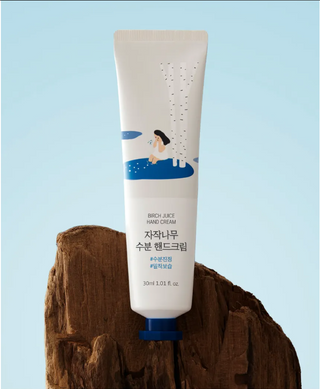Cream container labeled ROUND LAB Birch Juice Hand Cream 30ml, featuring natural ingredients and a sleek design.
