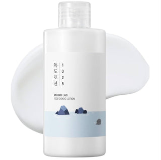 Round Lab 1025 Dokdo Lotion emulsion bottle with white and blue label, showcasing the skincare product in a clear container.