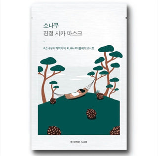ROUND LAB Pine Calming Cica face sheet mask lying flat, showing the packaging with green pine design and product name.