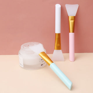 Seul Kare silicone mask brush in black, with a white ergonomic handle, designed for applying facial masks smoothly and evenly.